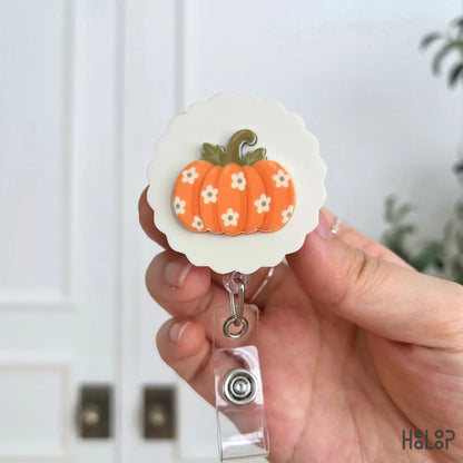 Orange floral pumpkin badge reel with dimensional acrylic topper and retractable ID holder
