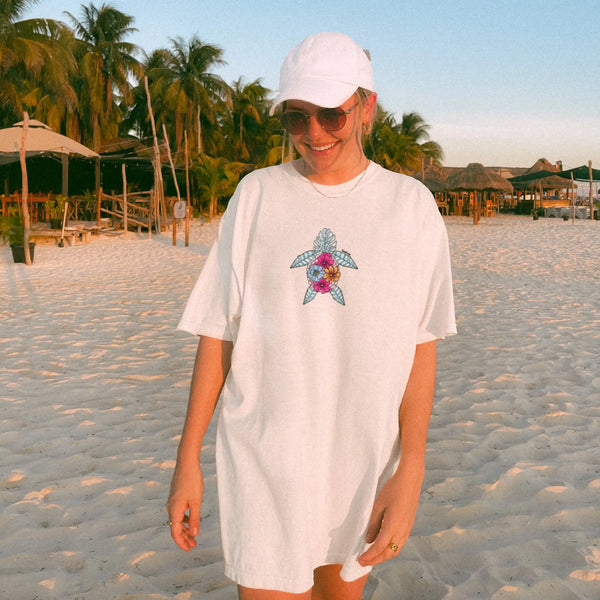  Unisex floral sea turtle white t-shirt styled on a model, perfect for beach lovers and ocean enthusiasts.