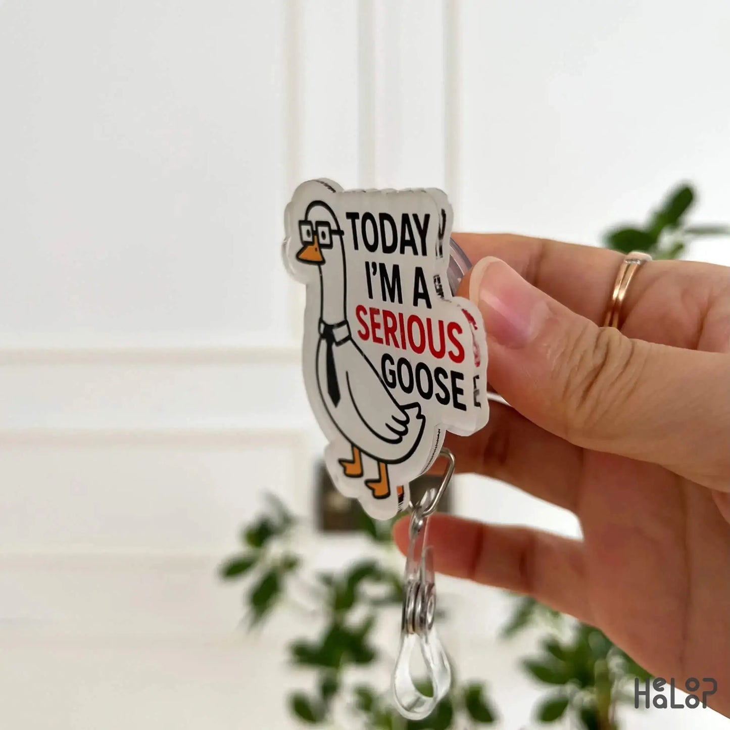 Side angle of funny goose badge reel showing retractable clip and glossy finish