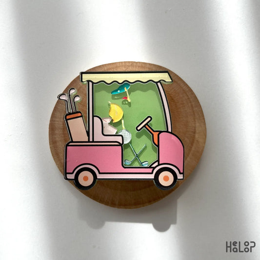 Fun golf cart shaker phone grip with floating golf accessories, displayed on wood background
