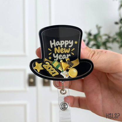 Happy New Year 2027 shaker badge reel with black top hat design, gold lettering, stars, and festive moving charms.