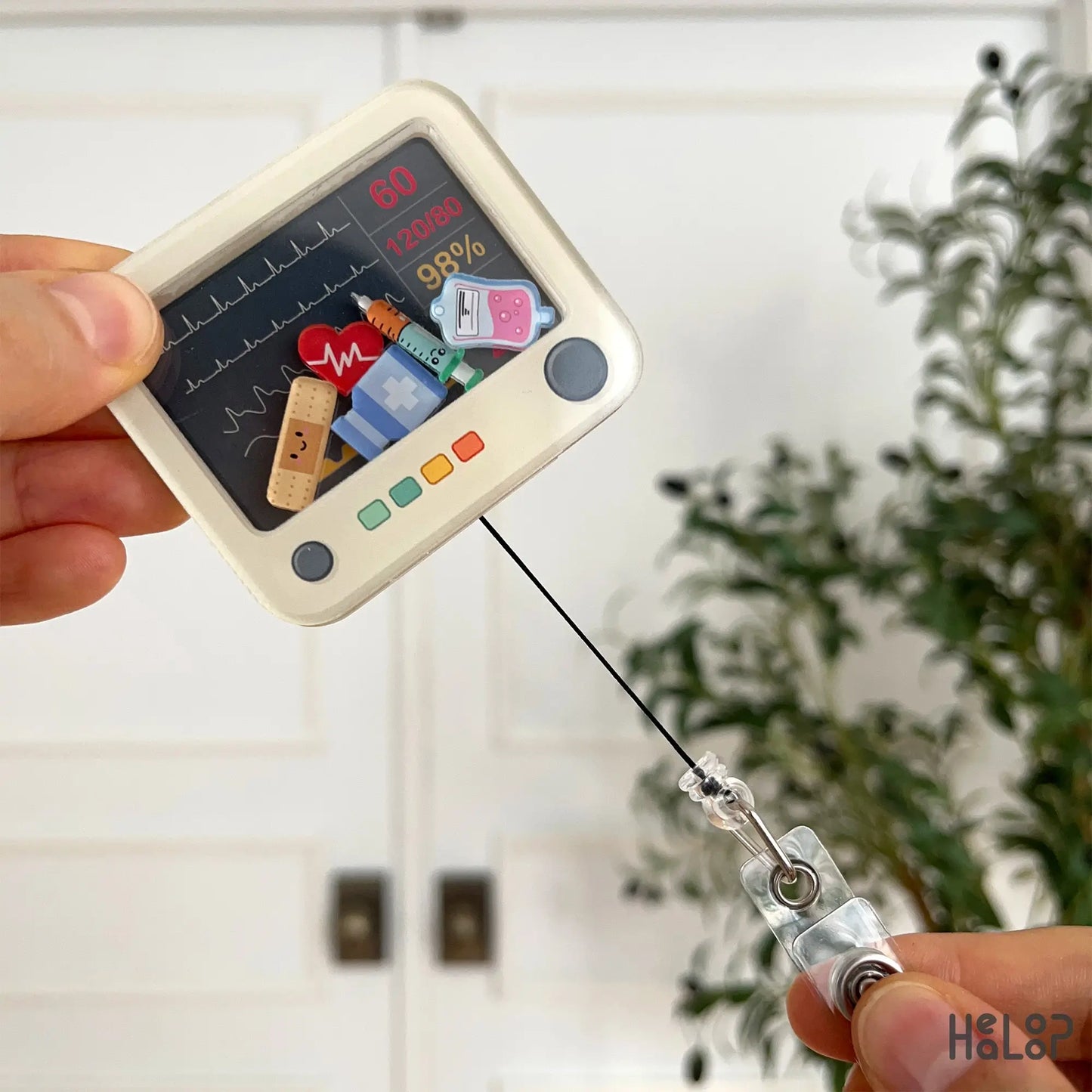 Retractable heart monitor badge reel extended to show cord and clip function.