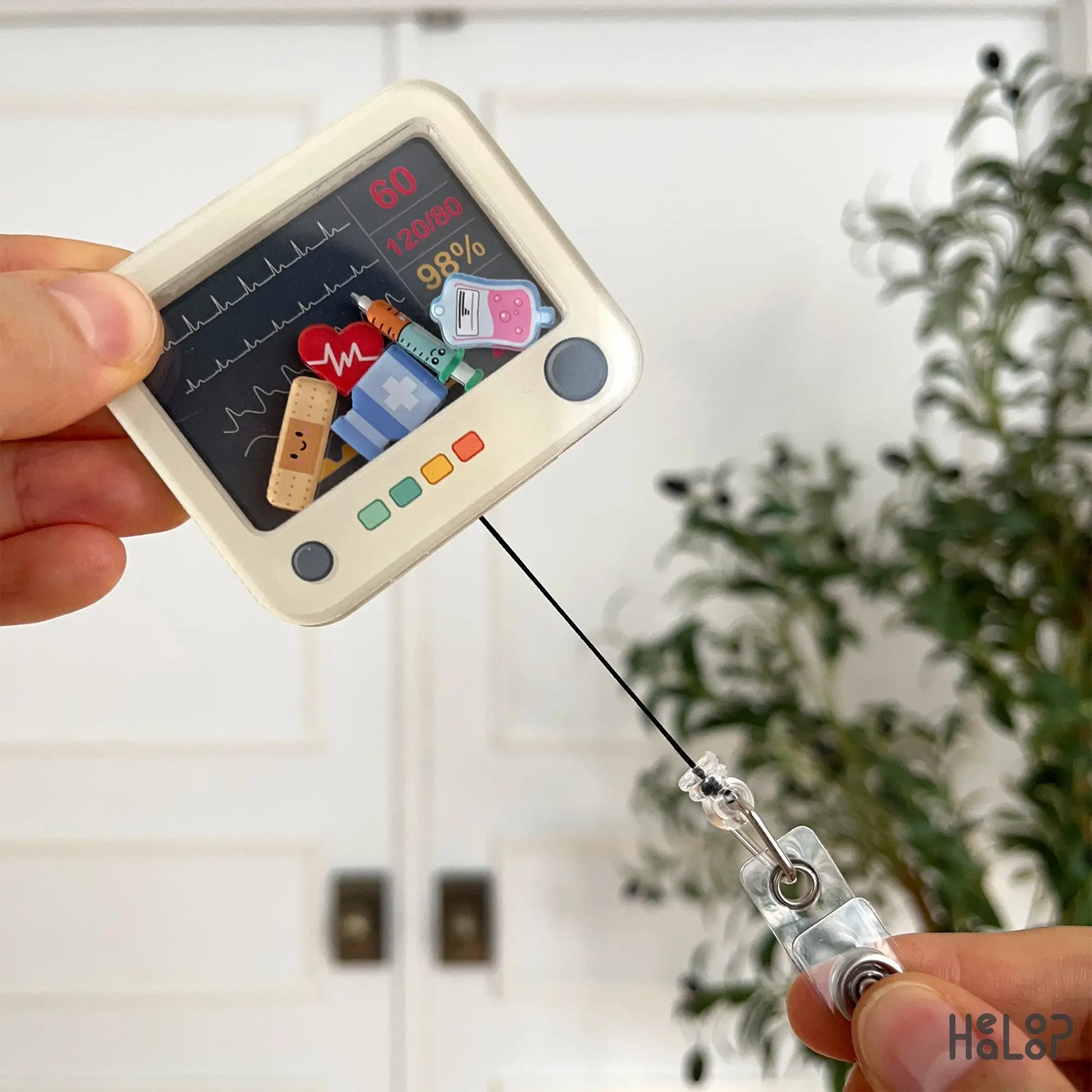 Retractable heart monitor badge reel extended to show cord and clip function.