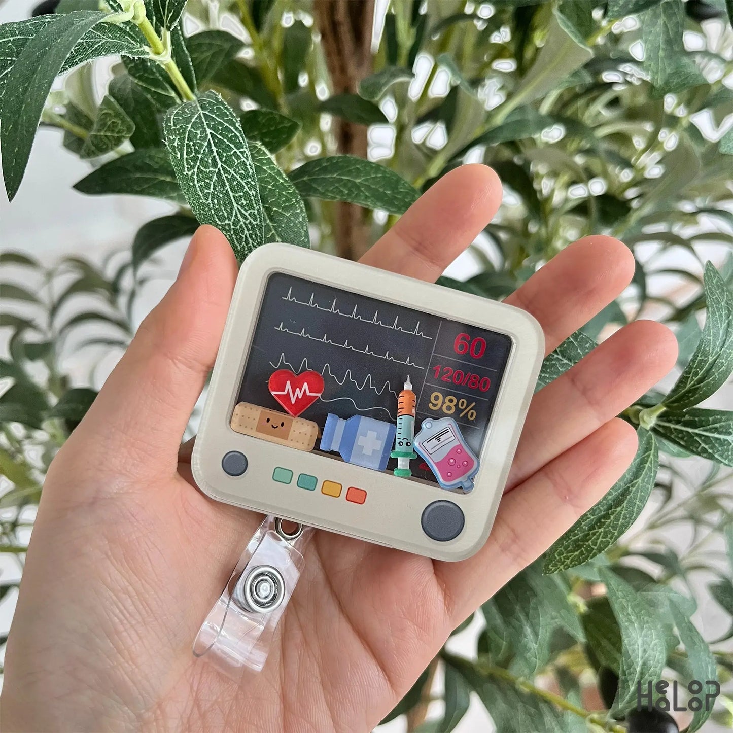 Heart monitor shaker badge reel with cute EKG screen and medical icons for nurses.