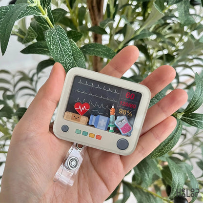 Heart monitor shaker badge reel with cute EKG screen and medical icons for nurses.
