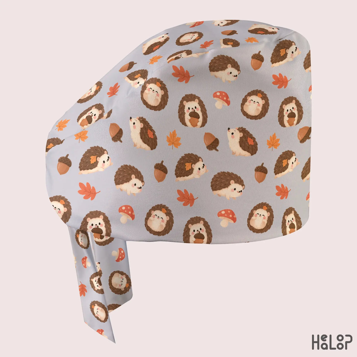 Side profile of the HEALOOP Hedgehog Classic Scrub Cap, highlighting adorable brown hedgehogs, orange fall leaves, acorns, and red mushrooms on a soft gray background.