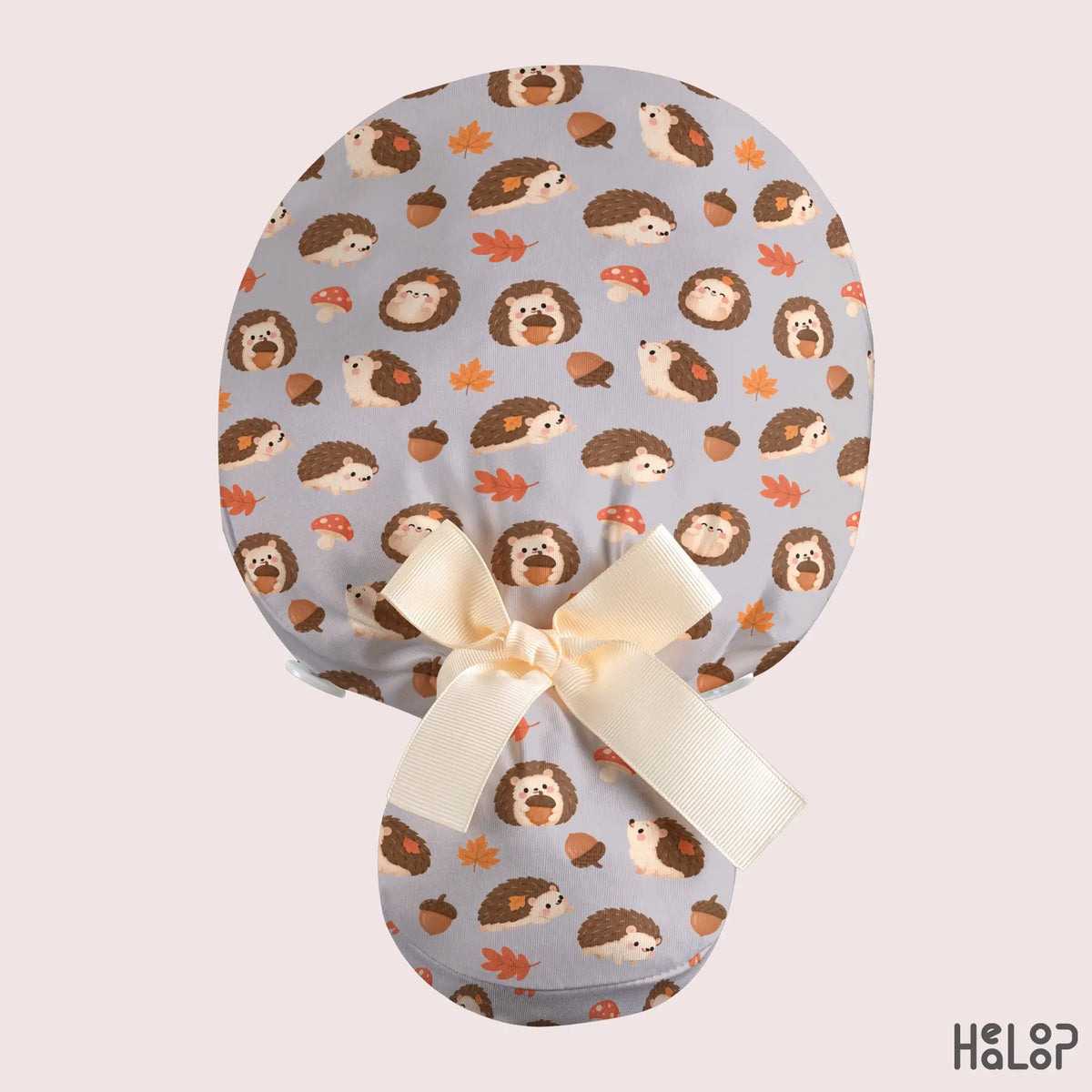 Hedgehog ponytail scrub cap with adorable woodland hedgehog pattern, fall leaves, acorns, mushrooms, and cream ribbon bow on the back.