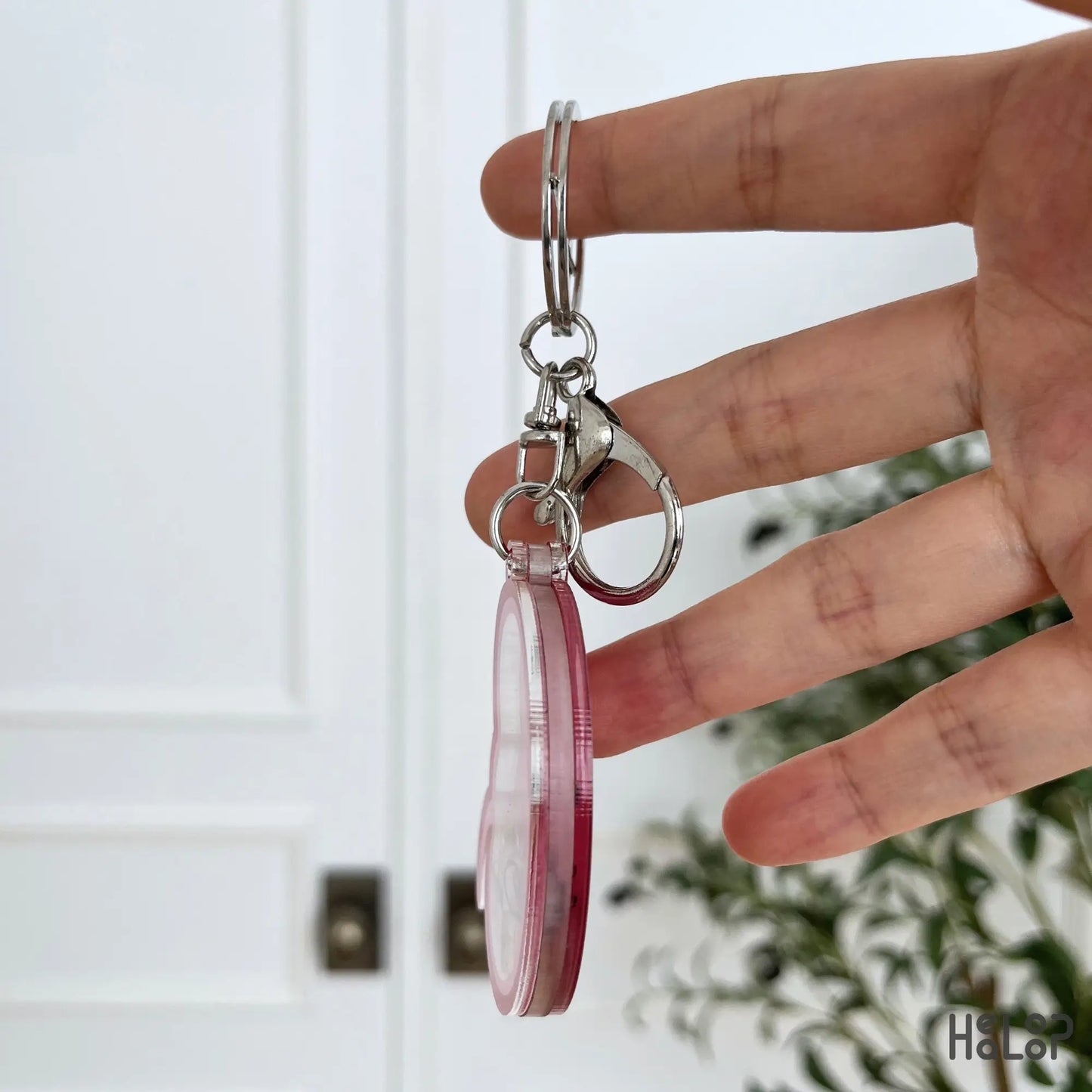 Side view of the layered acrylic Kidney Shaker Keychain showing its shaker construction and silver hardware.