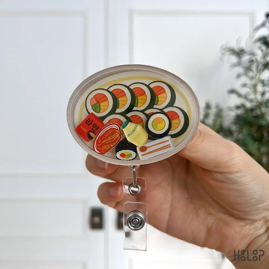 Front-facing Korean kimbap-themed shaker badge reel with ramen and snack charms.