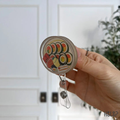 Side profile of Korean kimbap shaker badge reel highlighting depth and acrylic build.