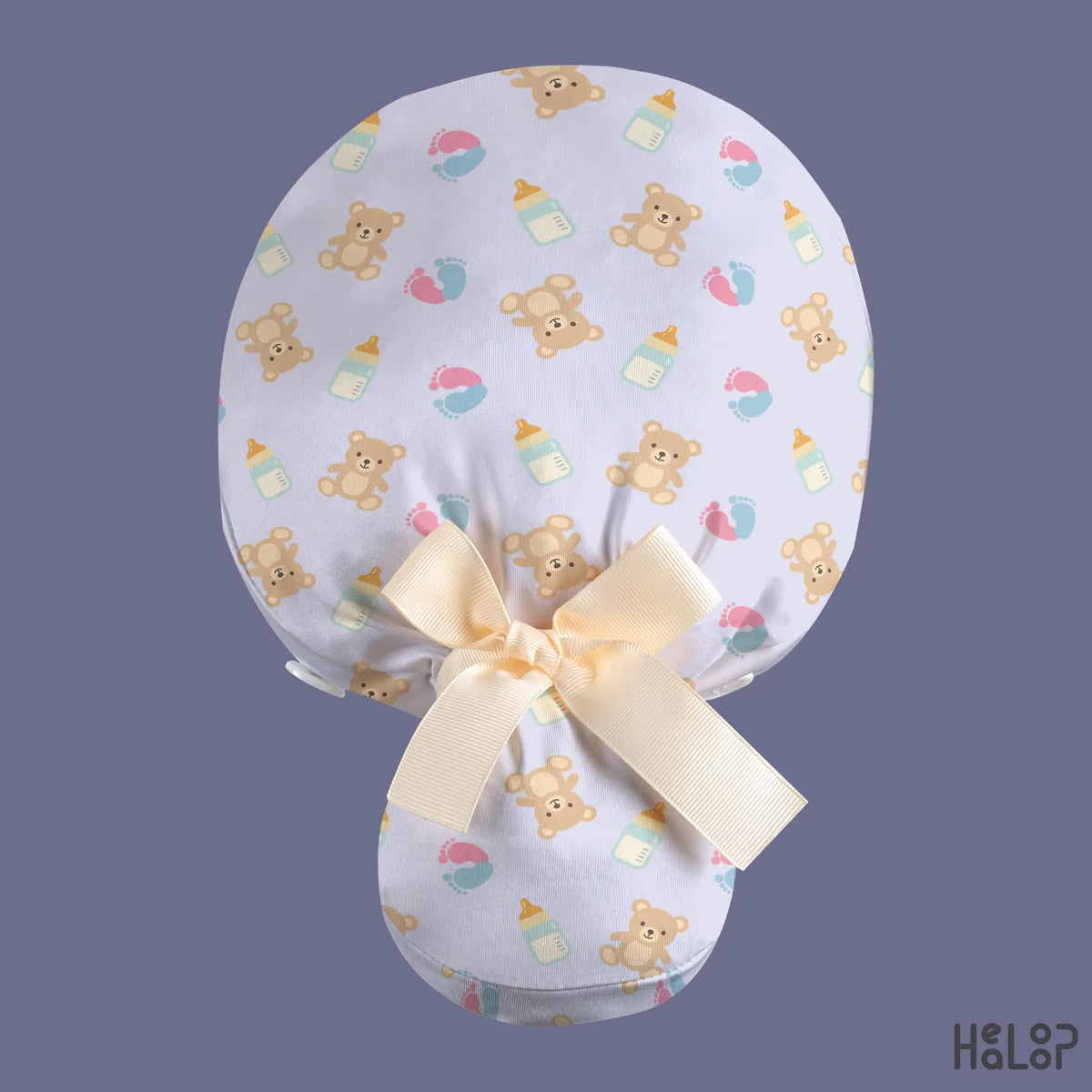 L&D NICU ponytail scrub cap in light lavender with teddy bears, pastel baby footprints, baby bottles, and a cream ribbon bow at the back.