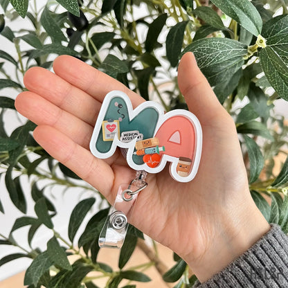 MA shaker badge reel shown in hand for size reference and everyday wear