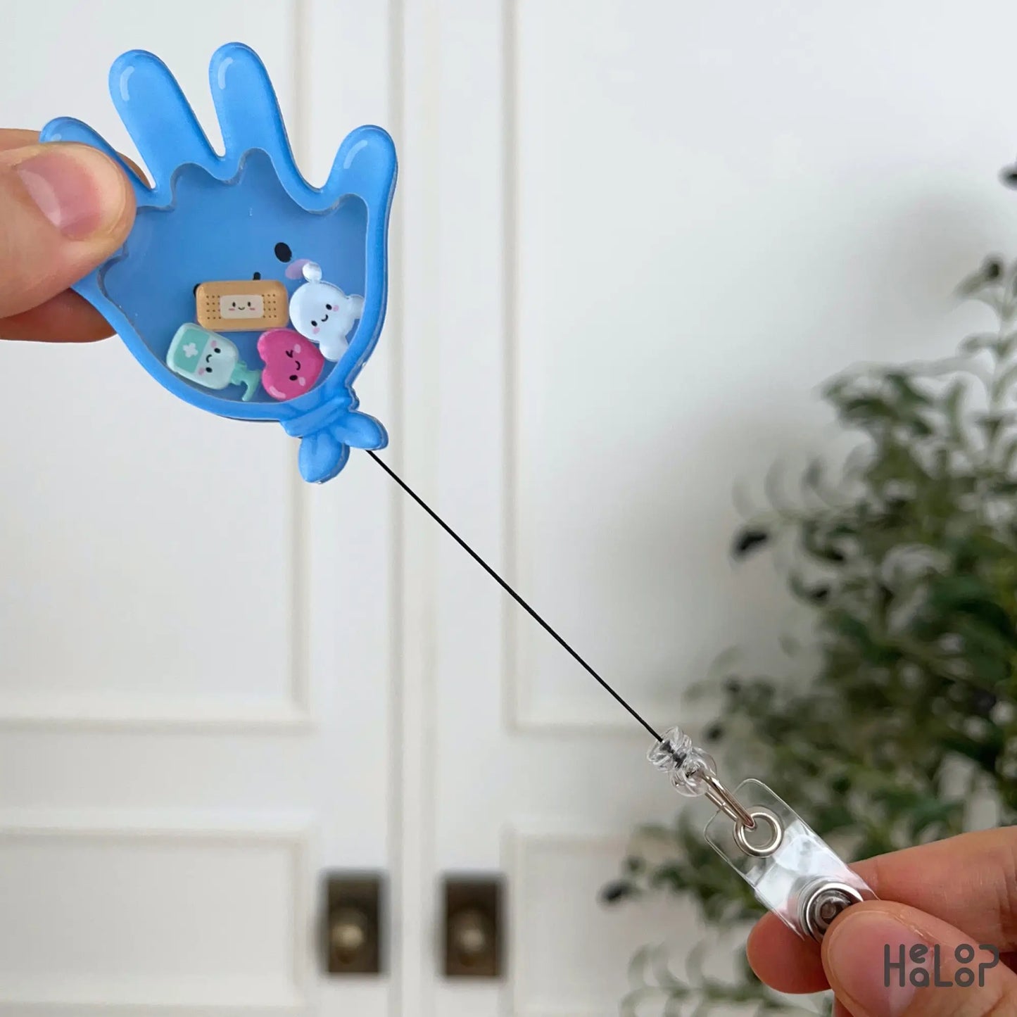 Medical Glove Shaker Badge Reel with extended retractable cord for holding a nurse or healthcare worker ID badge.