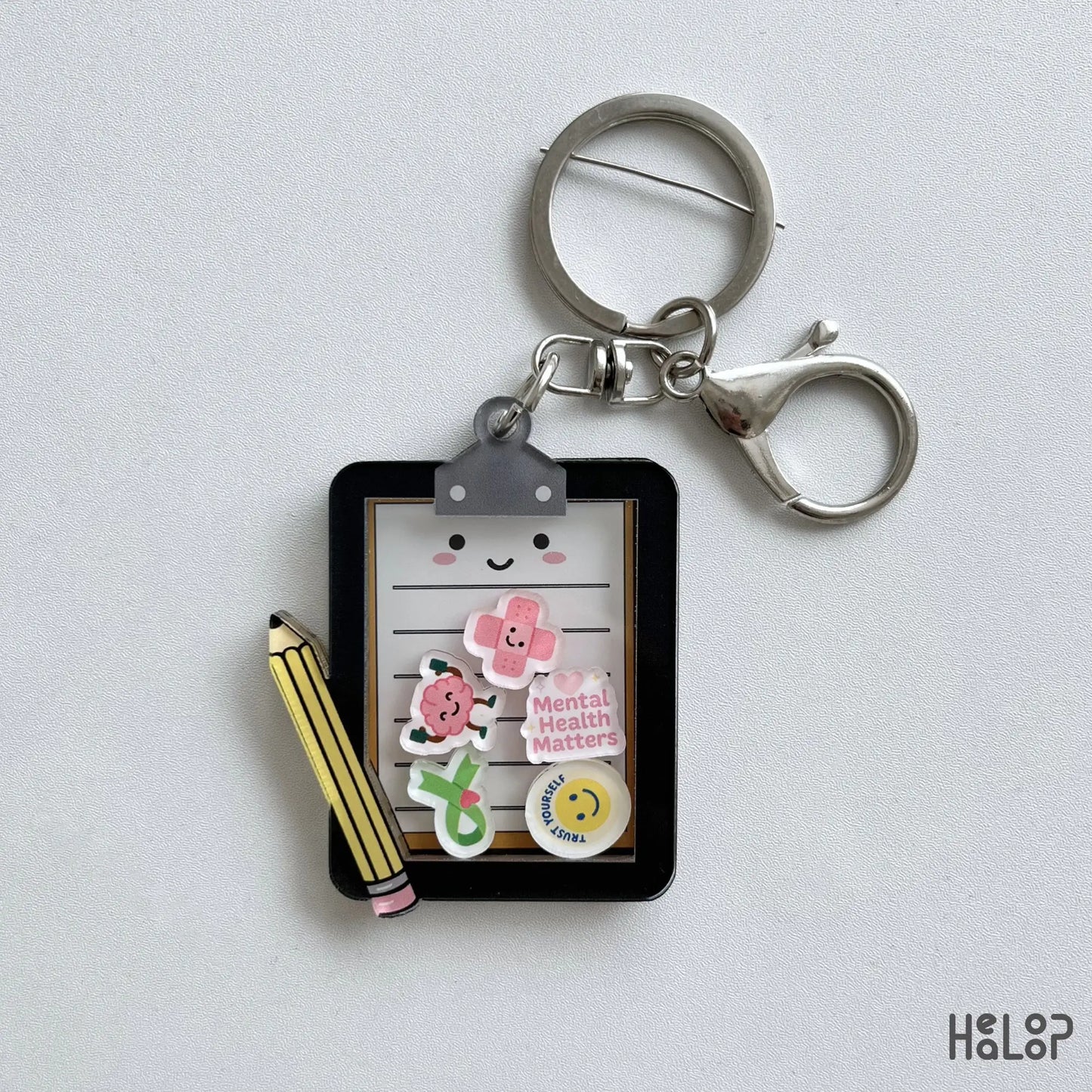 Cute Mental Health Board Shaker Keychain featuring a clipboard, pencil, and colorful moving mental health charms.