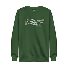 Flat lay of My Tummy Hurts sweatshirt in Forest Green with embroidered text, 'My tummy hurts but I'm being really brave about it'