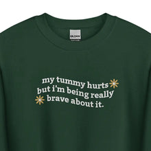 Flat lay of My Tummy Hurts sweatshirt in Forest Green with embroidered text, 'My tummy hurts but I'm being really brave about it' zoom