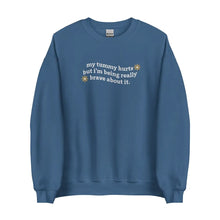 Flat lay of My Tummy Hurts sweatshirt in Indigo Blue with embroidered text, 'My tummy hurts but I'm being really brave about it'