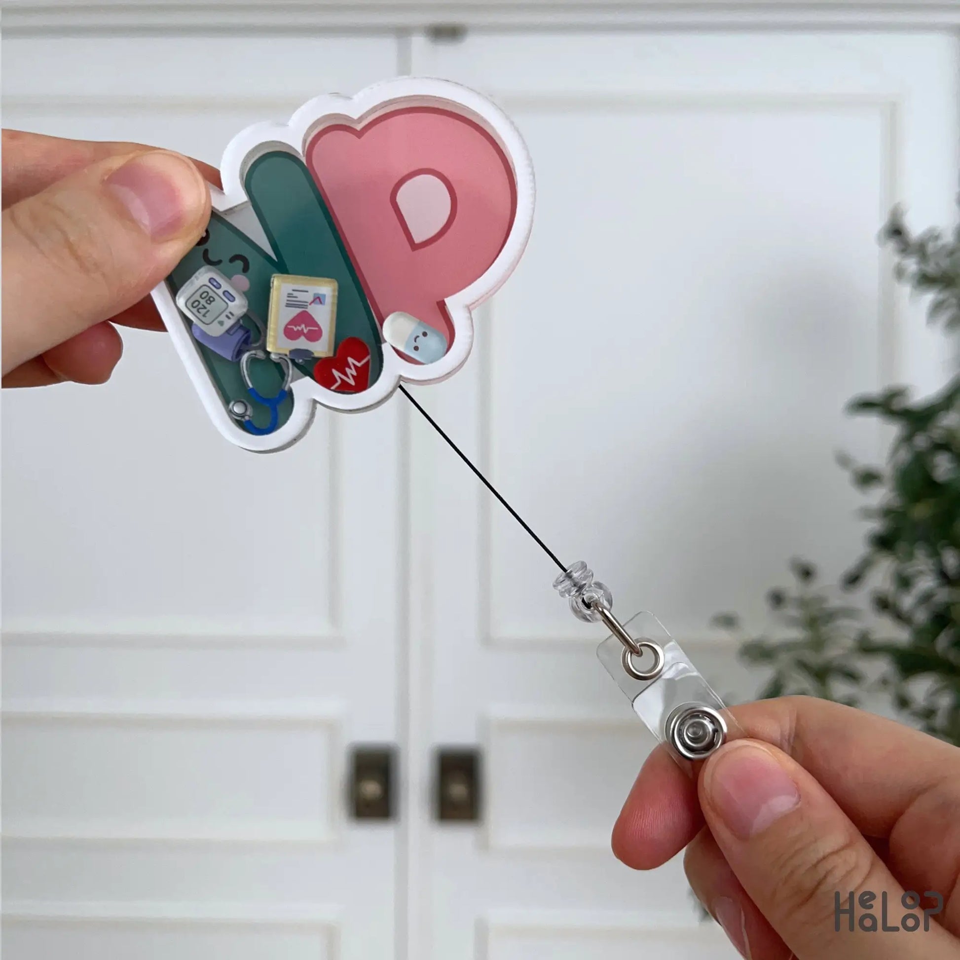 NP retractable badge reel with extendable cord and interactive shaker charms designed for Nurse Practitioners.
