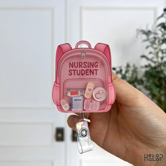 Detailed front view of Healoop Nursing Student badge reel with syringe, notebook, and bandage charms