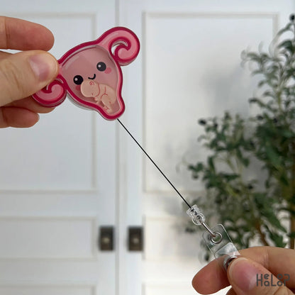 OBGYN uterus-shaped shaker badge reel shown with fully extended retractable cord.