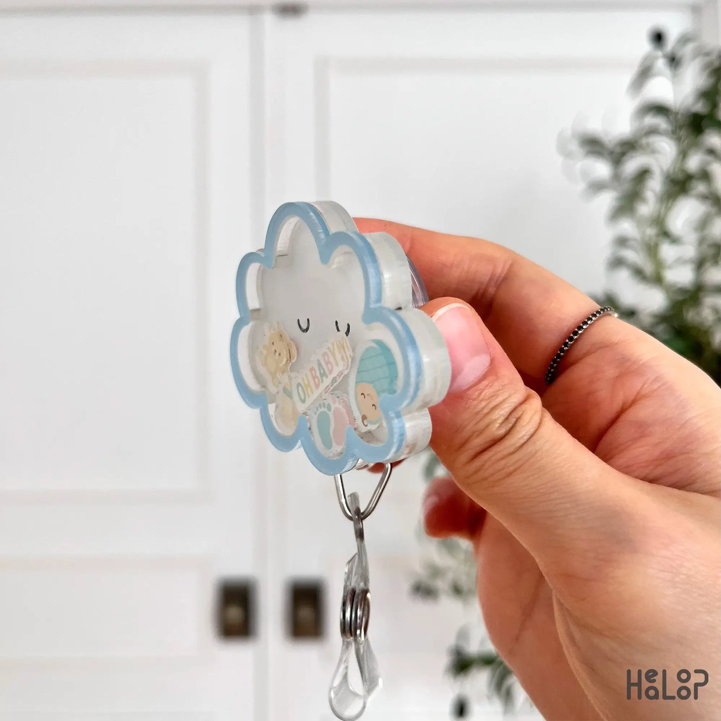 3D acrylic side view of the Oh Baby cloud shaker badge reel featuring baby bottle and teddy charms.
