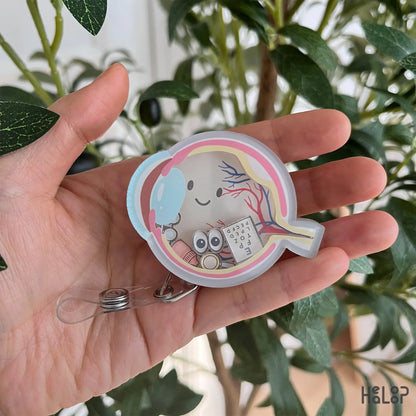 Ophthalmology shaker badge reel featuring cute eye anatomy illustration with floating charms.