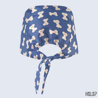 Ortho Bone Classic Scrub Cap back view showing cute cream bone illustrations on blue fabric, elastic back opening and adjustable fabric ties.