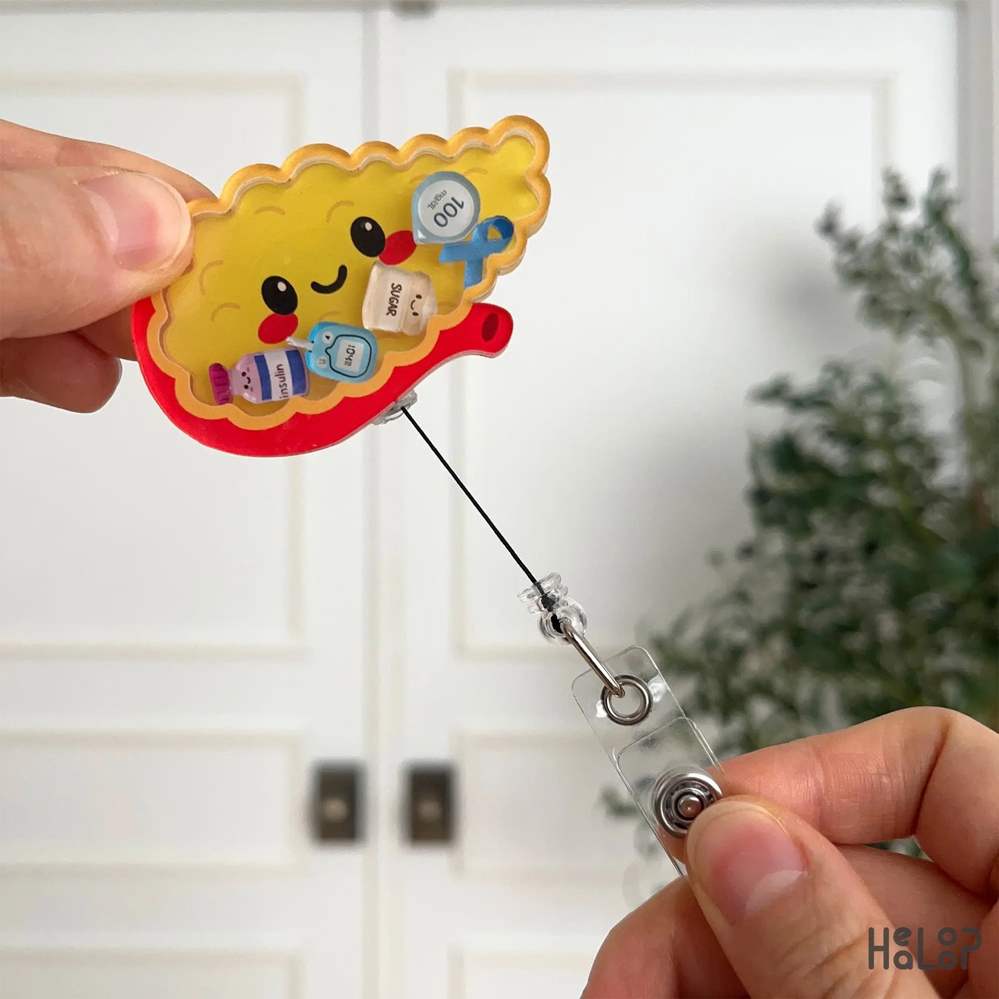 Retractable pancreas badge reel extended to show smooth pull cord for healthcare ID badges