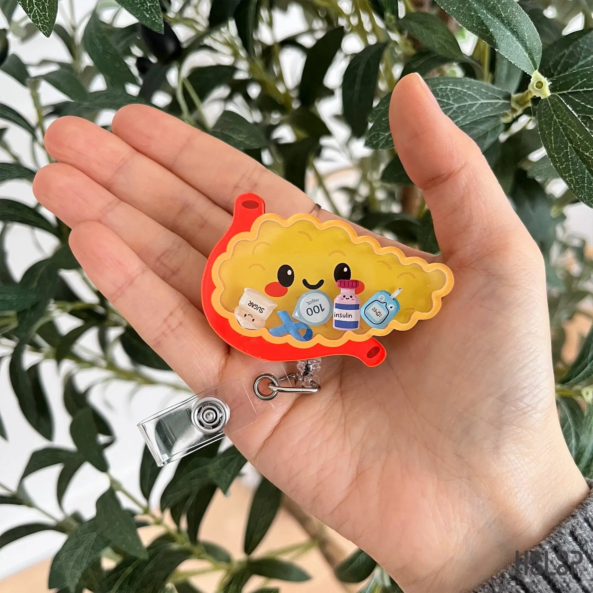 Pancreas shaker badge reel featuring a cute anatomy design with diabetes themed charms
