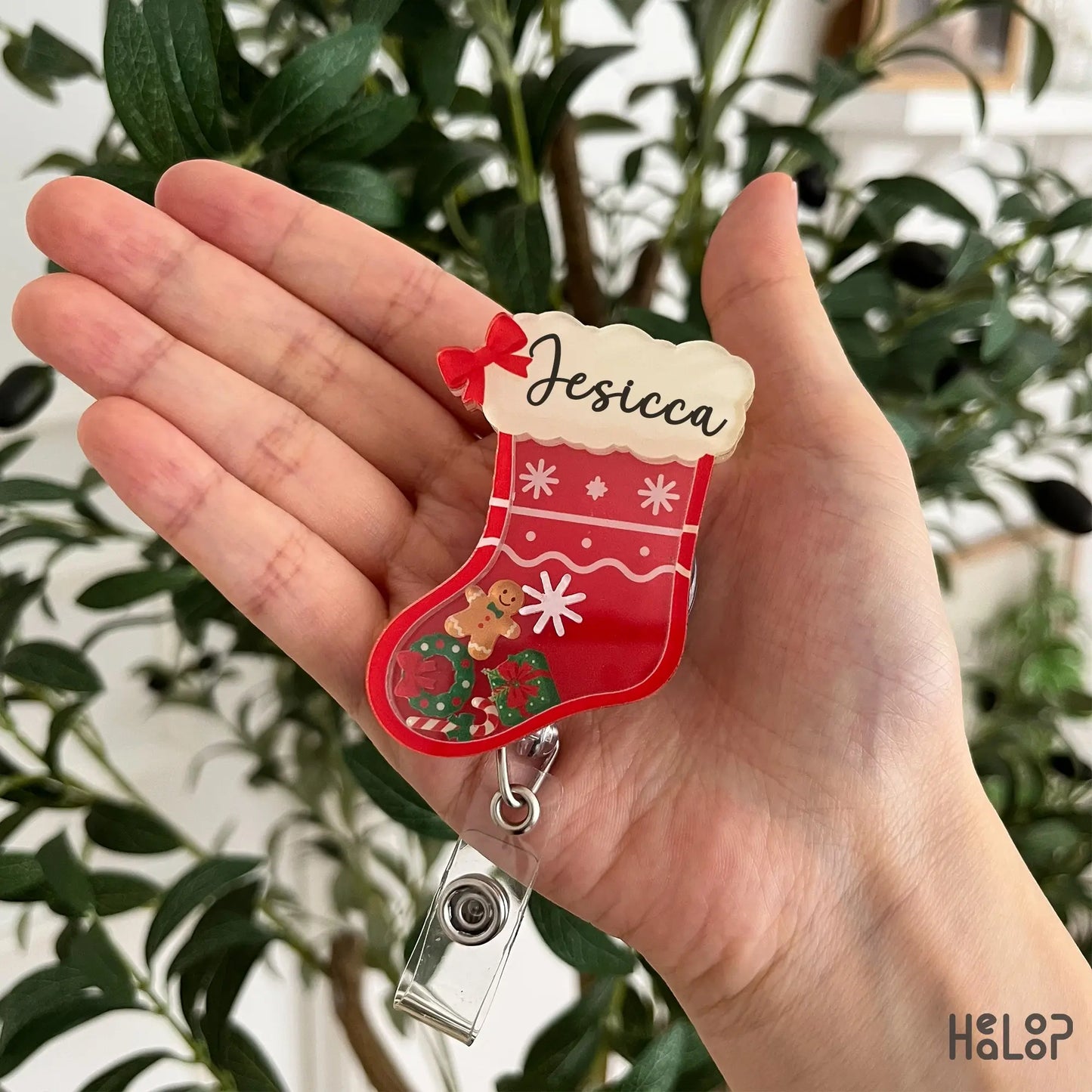 Personalized Christmas stocking shaker badge reel with a custom name and festive movable holiday charms.