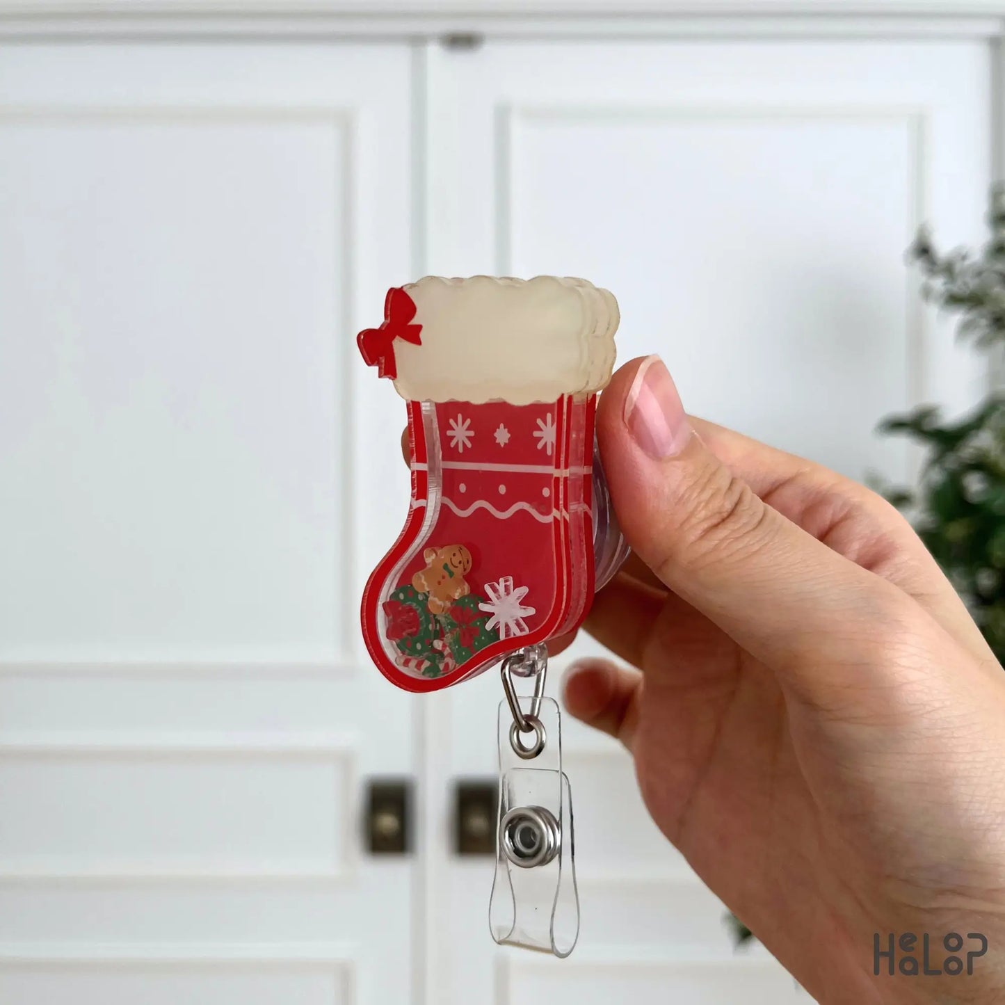 Side profile of a personalized Christmas stocking shaker badge reel with layered acrylic construction.
