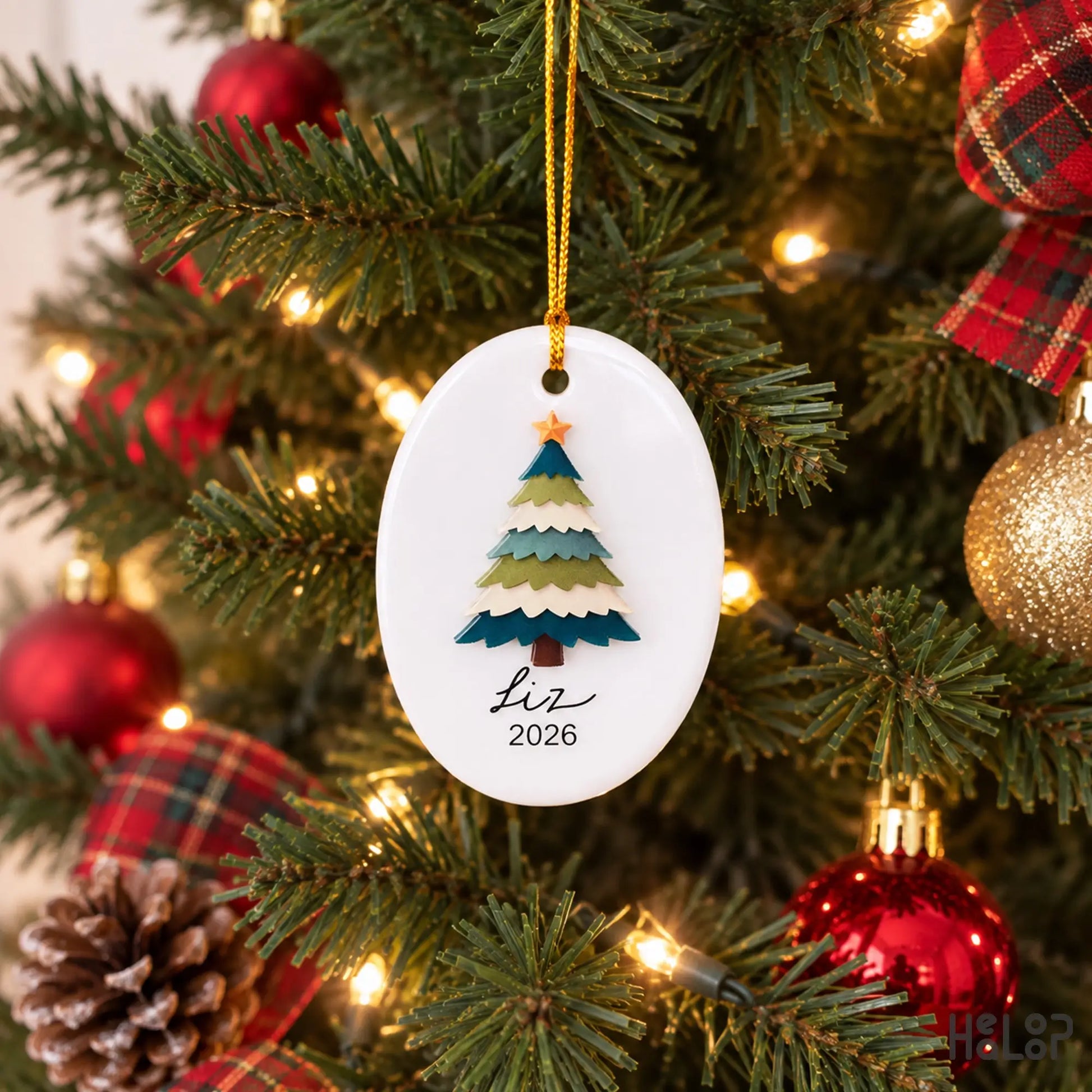 Personalized Liz ceramic and acrylic Christmas ornament hanging on a Christmas tree with holiday lights