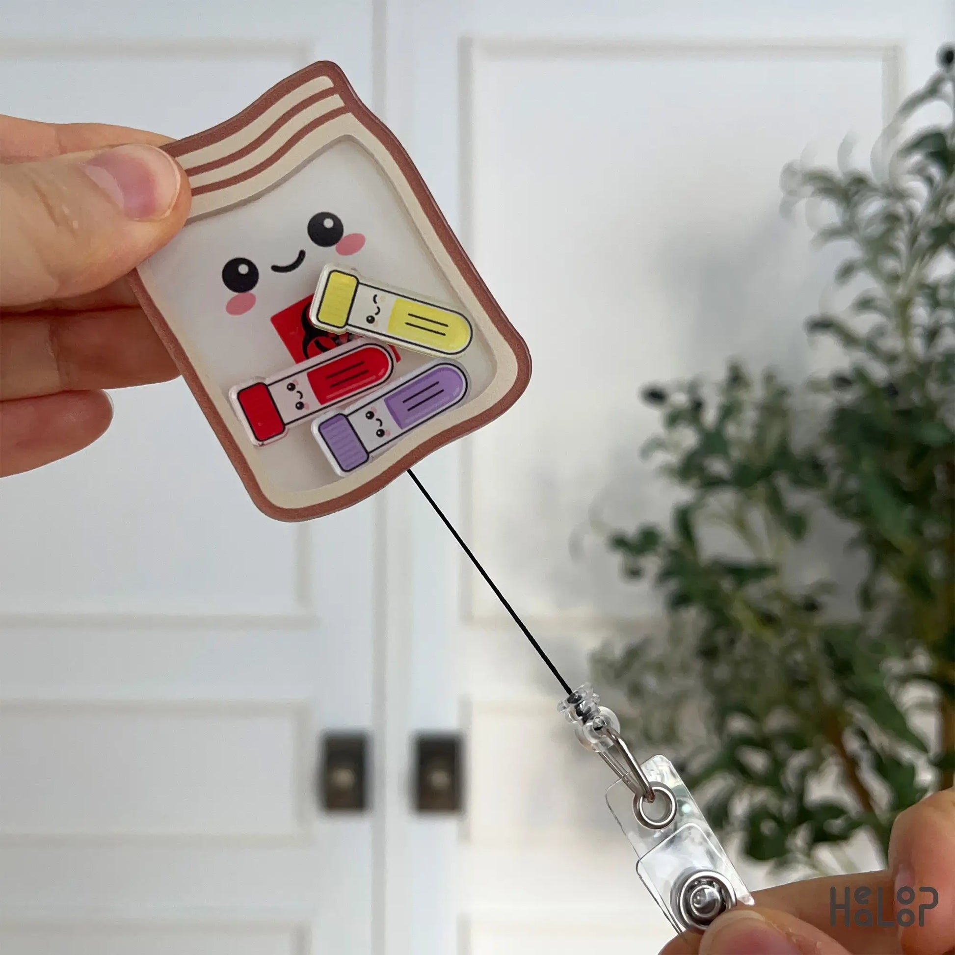 Biohazard shaker badge reel for phlebotomists shown with fully extended retractable cord.