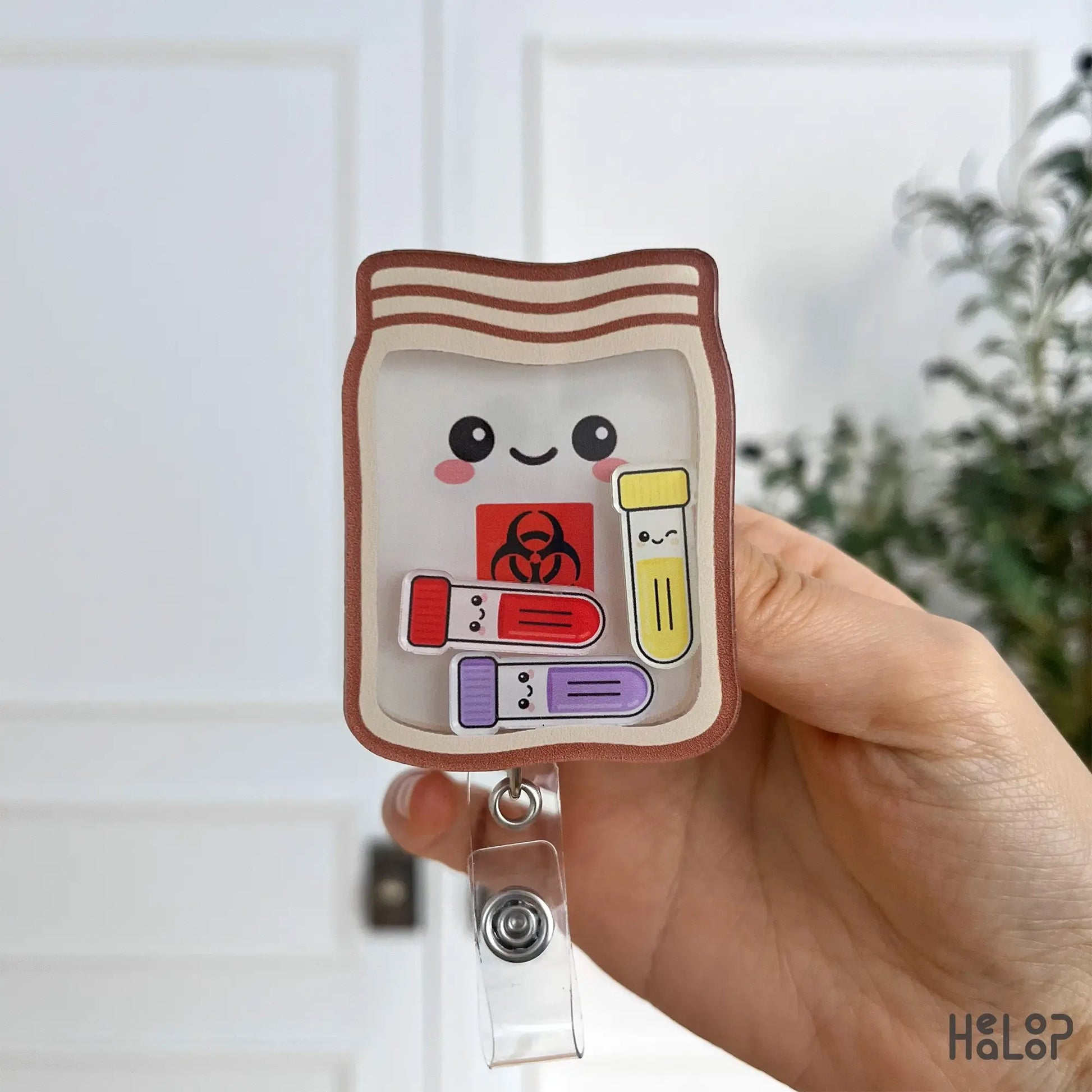 Front-facing phlebotomist biohazard shaker badge reel featuring specimen bag design and colorful tubes.