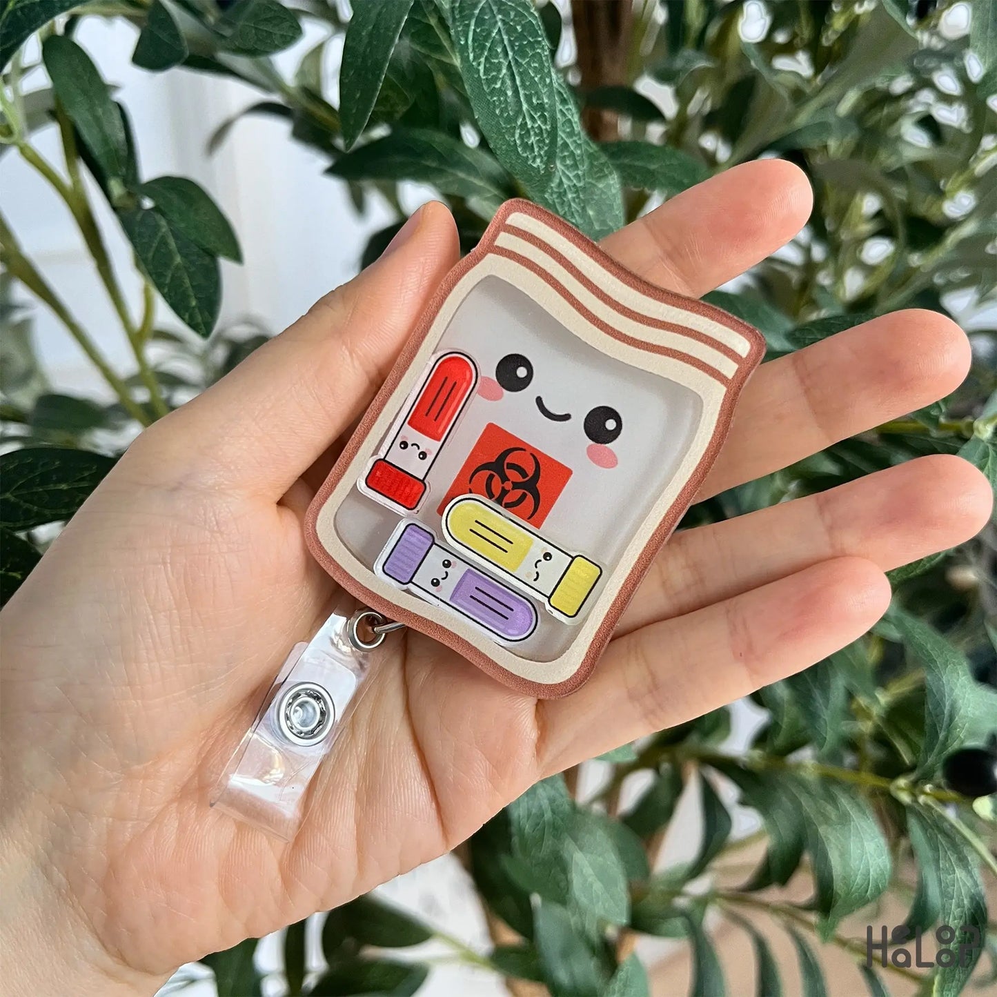 Handheld phlebotomist biohazard shaker badge reel with cute specimen bag and test tube charms.