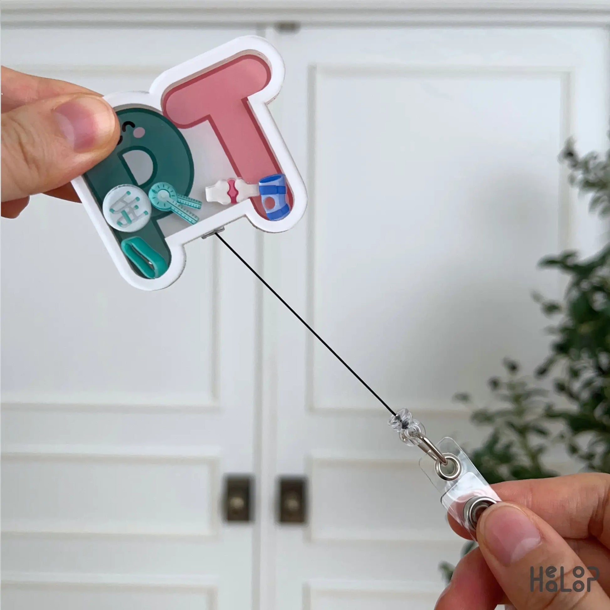 Retractable PT Shaker Badge Reel with extended pull cord and physical therapy themed shaker charms for physical therapists and PTA professionals.