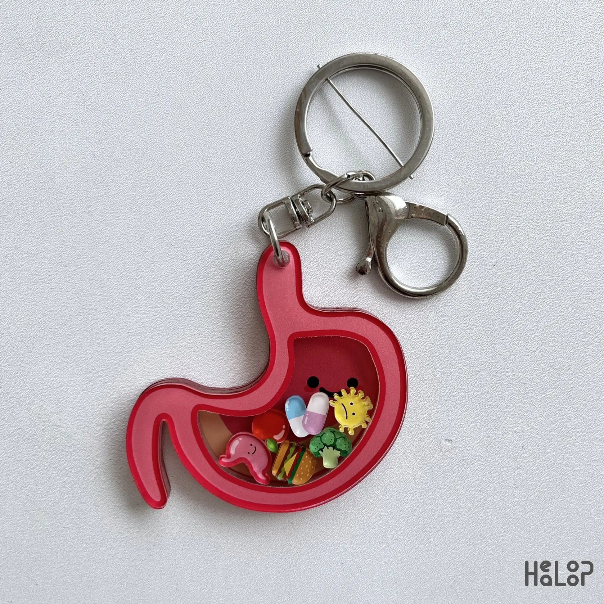 Pink stomach shaker keychain with colorful charms and silver key ring on a white background.