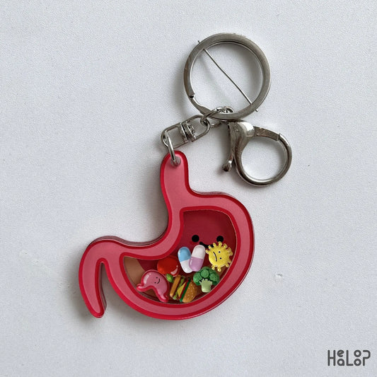 Pink stomach shaker keychain with colorful charms and silver key ring on a white background.