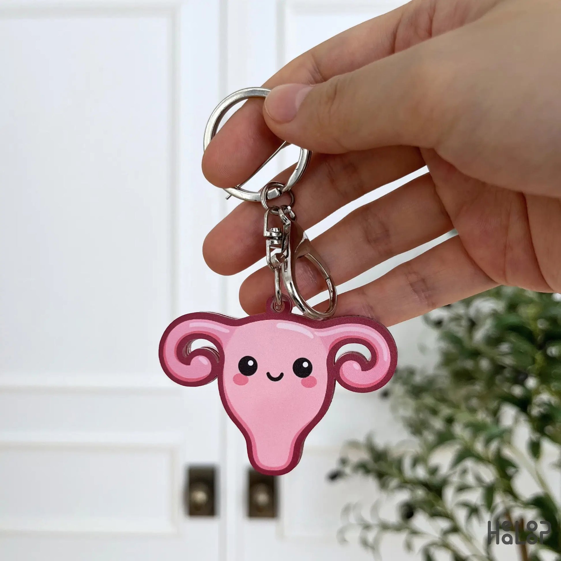 Back view of Healoop pink uterus keychain with cute smiling face design