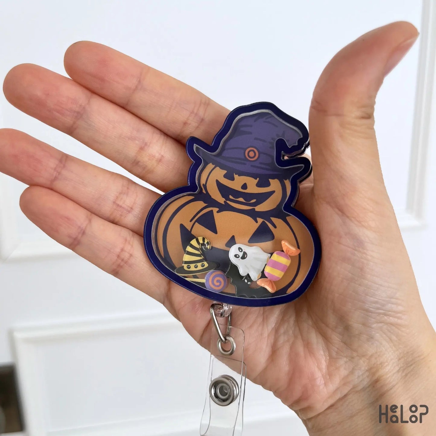 Detailed close-up of Pumpkin Halloween acrylic shaker badge reel with moving spooky charms