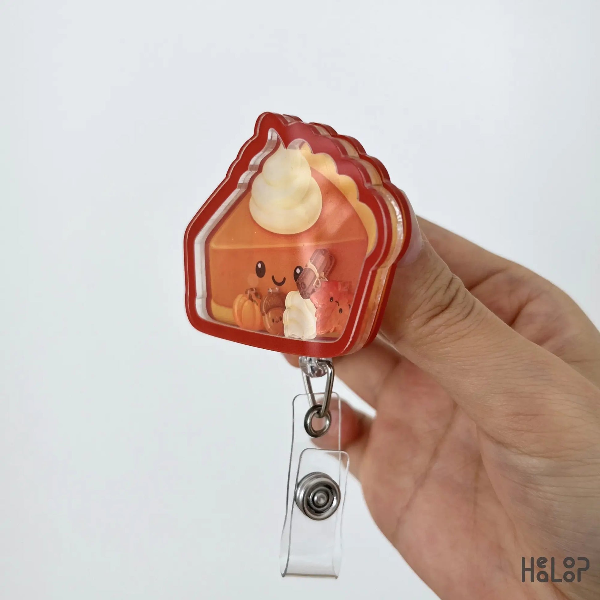 Side view of the Pumpkin Pie Shaker Badge Reel showing the layered acrylic construction and movable autumn-themed shaker pieces.