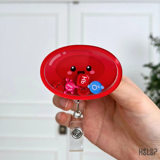 Cute Red Blood Cell Shaker Badge Reel displayed in hand, featuring movable Hb, iron, O₂, and red blood cell charms for healthcare professionals.