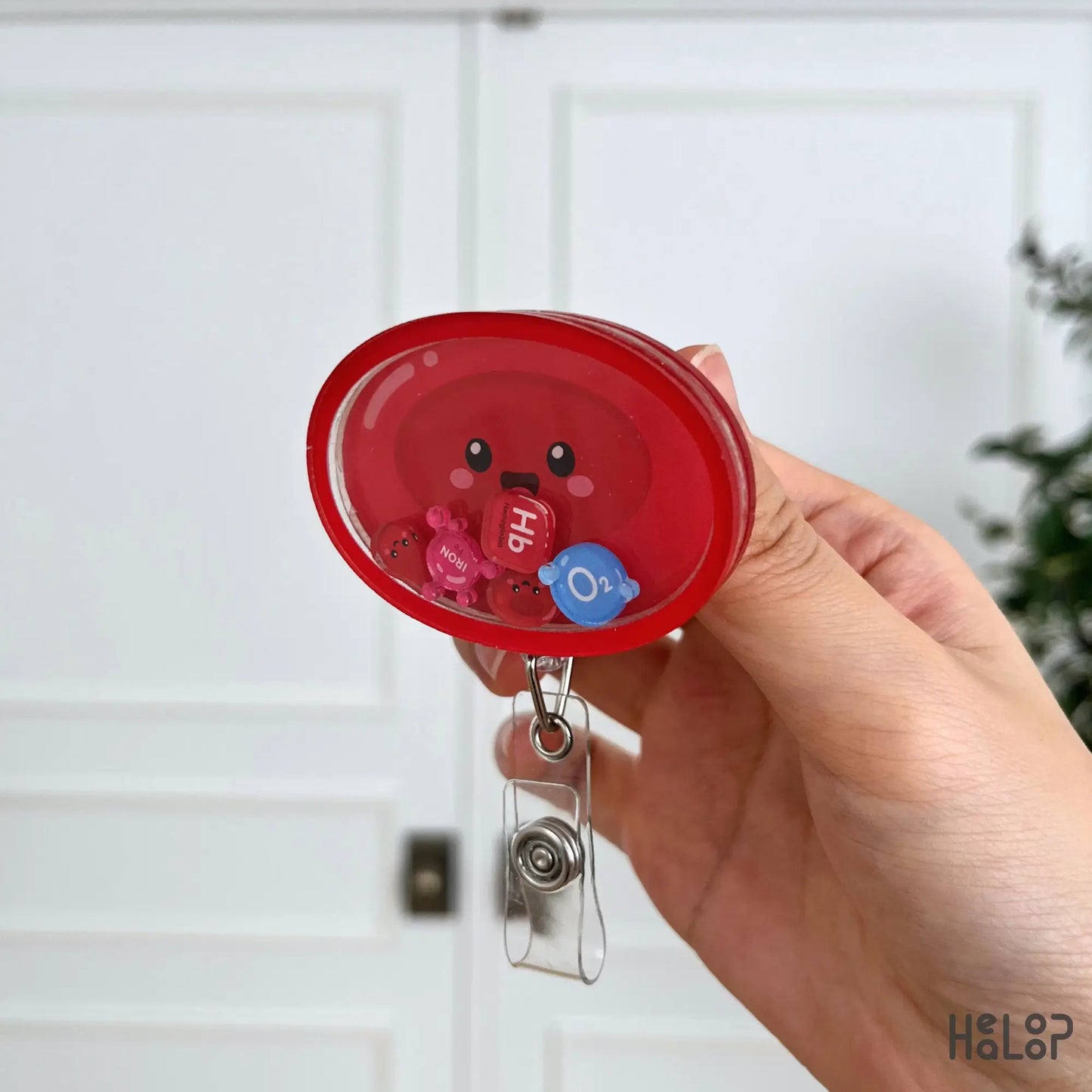 Side profile of the layered acrylic Red Blood Cell Shaker Badge Reel highlighting its shaker depth and movable hematology charms.
