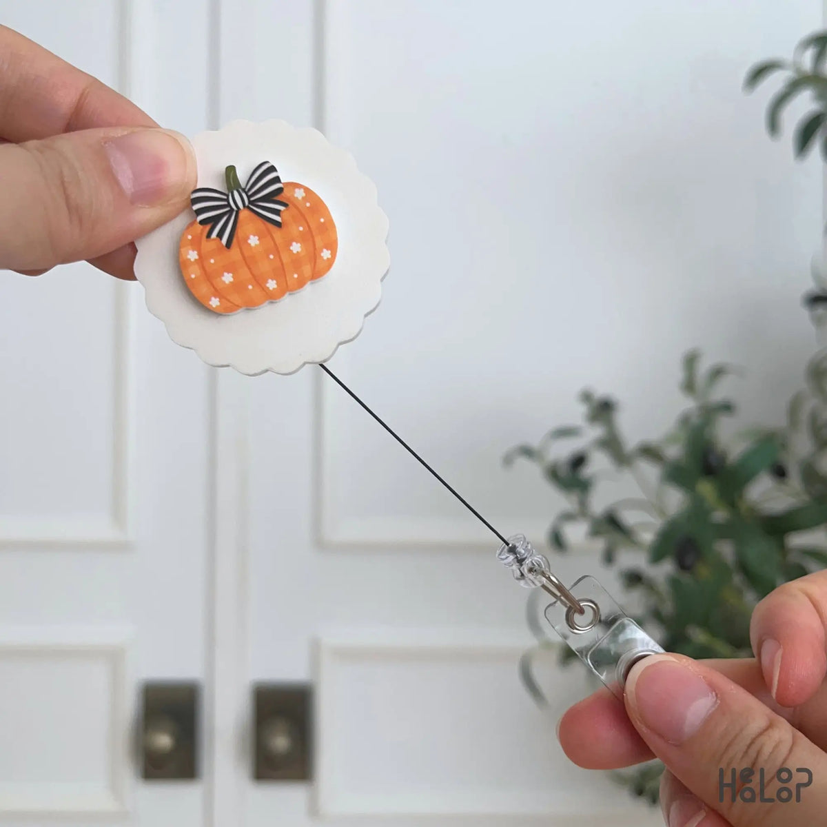 Retractable fall pumpkin badge reel extended to show the ID badge holder cord
