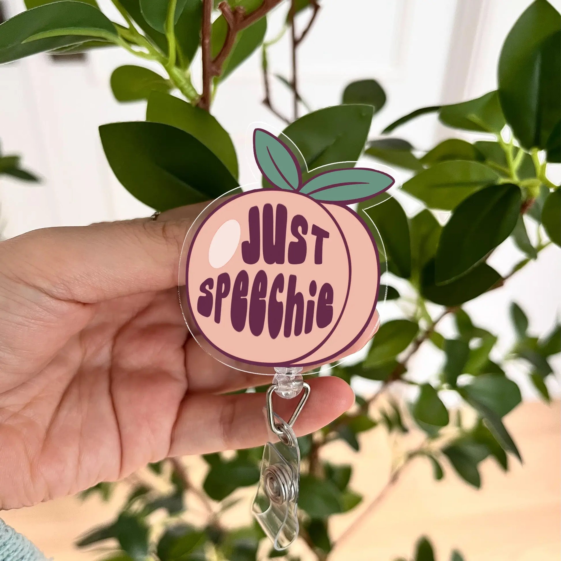 Funny Just Speechie acrylic badge reel – speech therapist gift idea with peach design