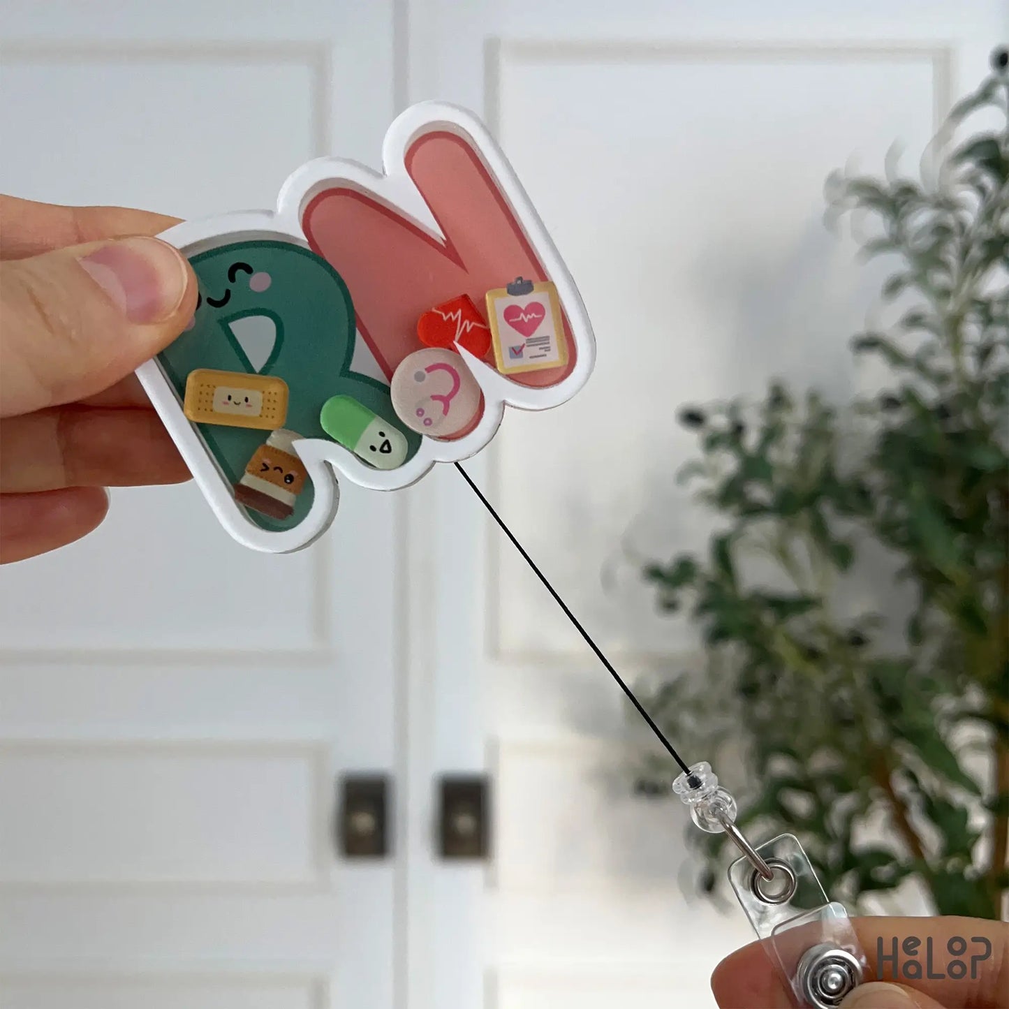 RN shaker badge reel with extended retractable cord, highlighting durability and design.