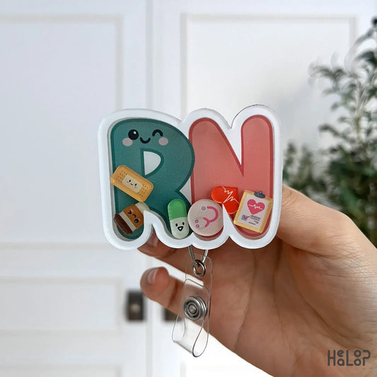Front-focused RN badge reel with cute medical icons and soft pastel colors.