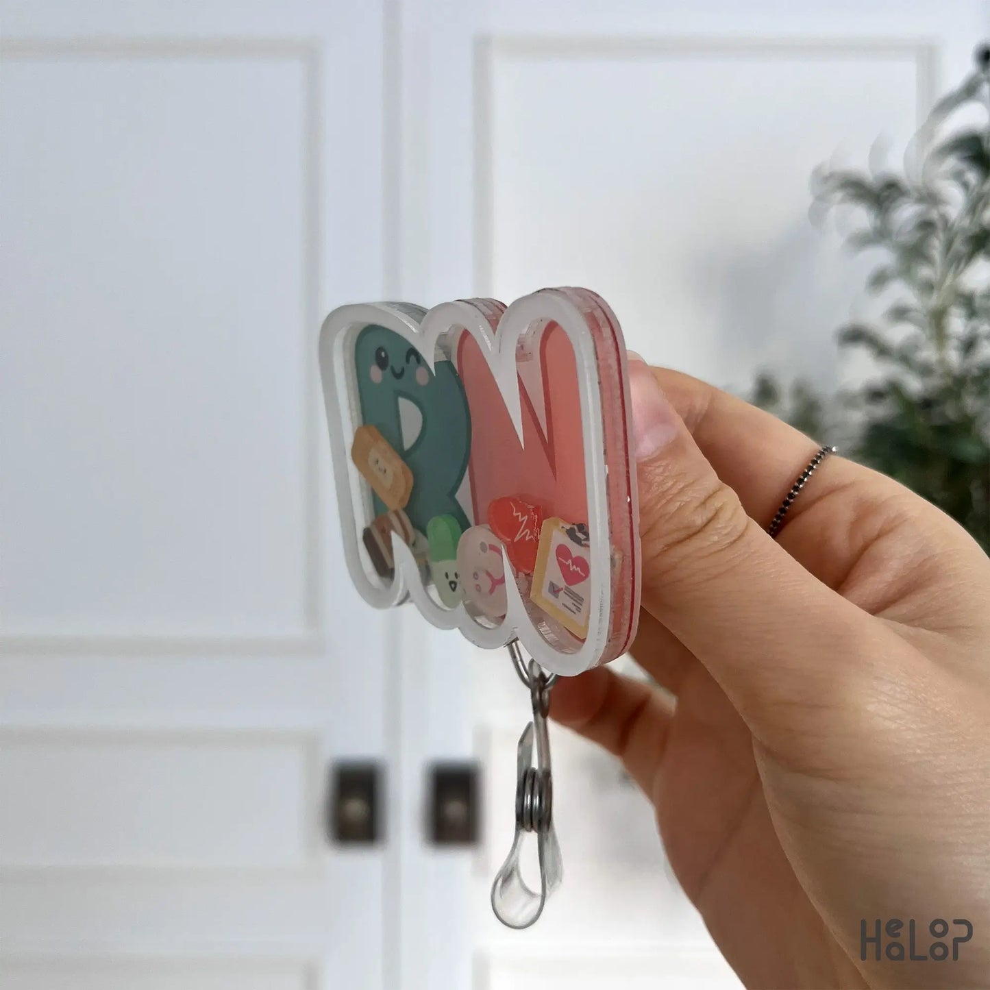 Layered acrylic side profile of RN shaker badge reel with clear charm depth.