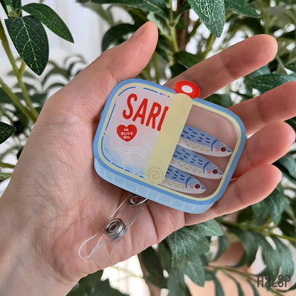 Sardine can shaker badge reel featuring three moving fish charms inside a tin design, cute retractable ID holder for nurses and healthcare workers