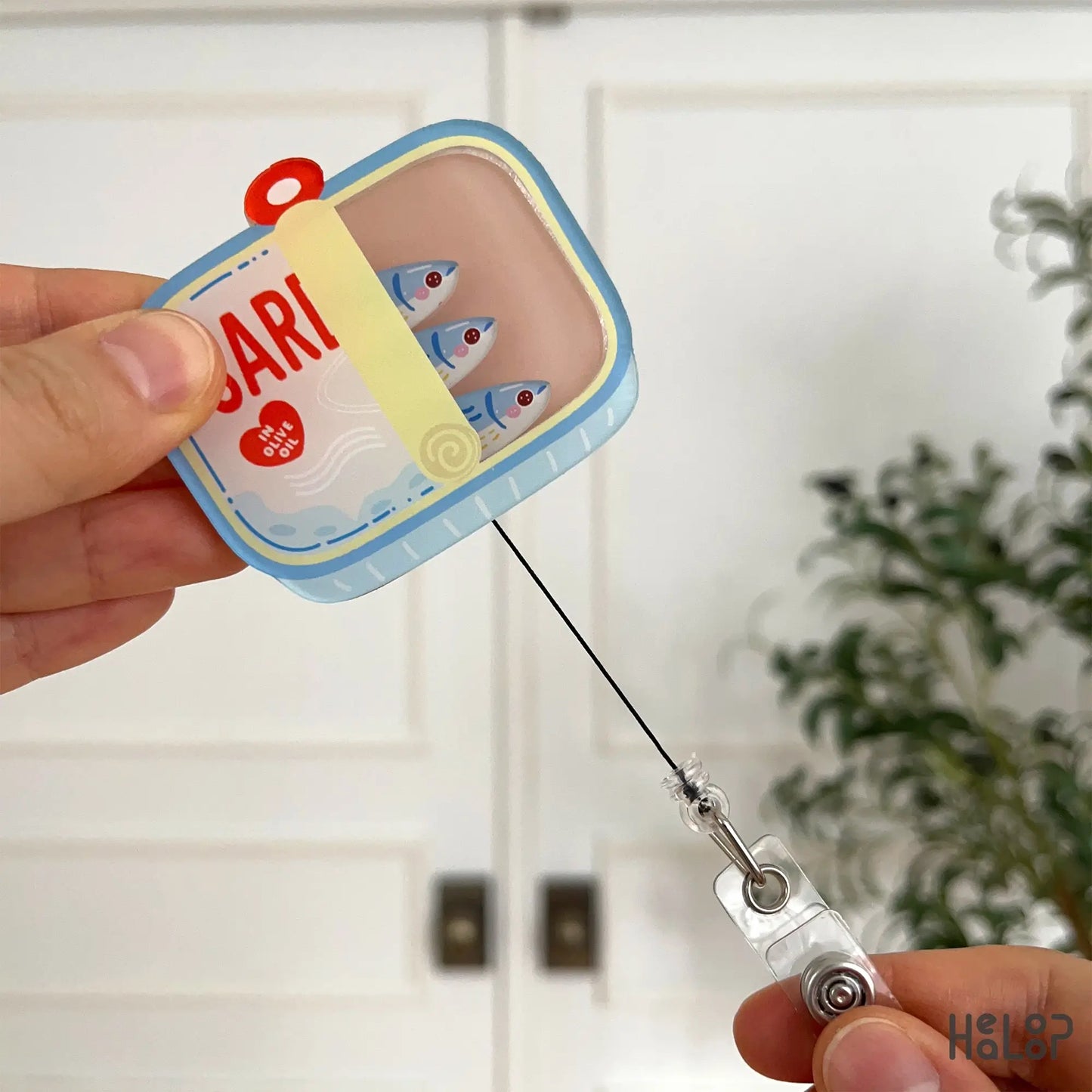 Pull-out view of sardine shaker badge reel showing retractable cord, durable acrylic ID holder for hospital and clinic staff